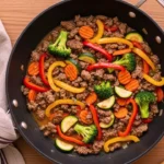 Poêlée de bœuf haché aux légumes colorés dans une grande poêle, prête pour un dîner rapide en 20 minutes.