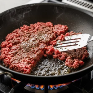 Bœuf haché en train de dorer dans une poêle.